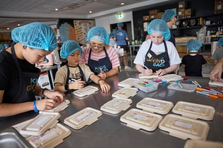 Children write messages of support to those who will receive the meals cooked by them.