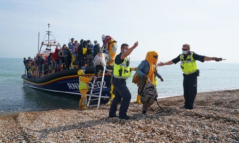 A group of people are brought ashore from the local lifeboat at Dungeness in Kent, after being picked up in the Channel. 