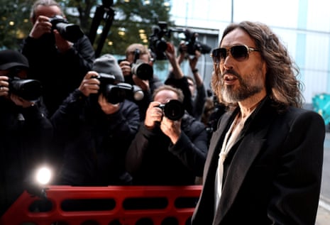 Russell Brand walks past a crowd of photographers at Southwark crown court.