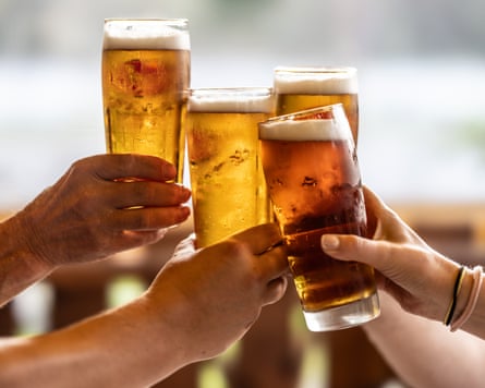 Closeup of the hands of people toasting with pints of beer