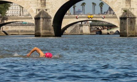A swimmer in a red cap in the Seine