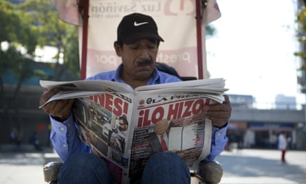 A man in Mexico City reads a newspaper whose front page declares ‘He did it!’, on the day Trump signed an executive order to jumpstart the wall.