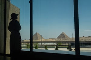 A silhouette of a visitor looking out towards the Giza pyramid complex