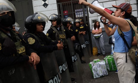 A protester shouts at a police line in Peru
