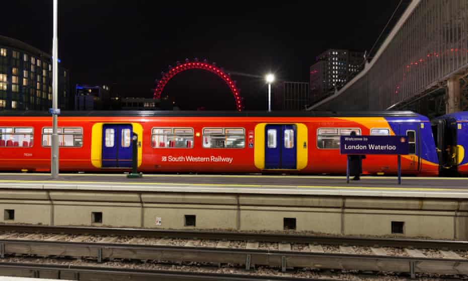Red train at the station, with London Eye visible in the background
