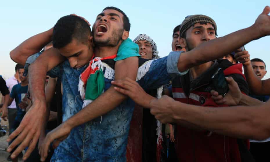 09 Oct 2015, Gaza, Gaza Strip --- Palestinians carry a wounded protester, who was shot by Israeli troops, during clashes near the Israeli border fence in northeast Gaza October 9, 2015.