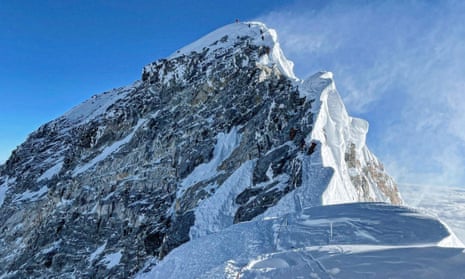 Mountaineers climbing a steep and snow-covered ridge