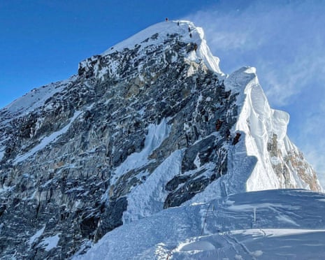 Mountaineers climbing a steep and snow-covered ridge