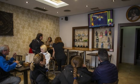 People watch the broadcast of Pedro Sanchez, president of the government of Spain, through a television in a bar in the center of Madrid.