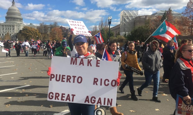 People carry signs during a 19 November 2017 protest for Puerto Rico in Washington DC. 