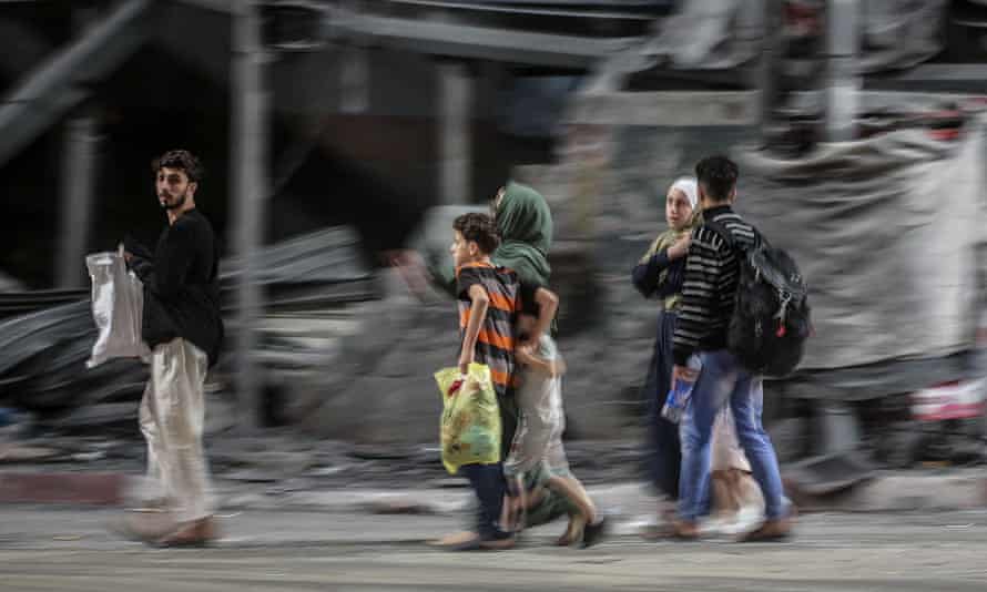 A Palestinian family flee from their house during Israeli airstrikes in the east of Gaza City early on Friday.