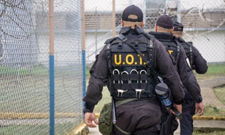 A tactical unit of three officers walks around barbwire fences in the Bayamón correctional complex.