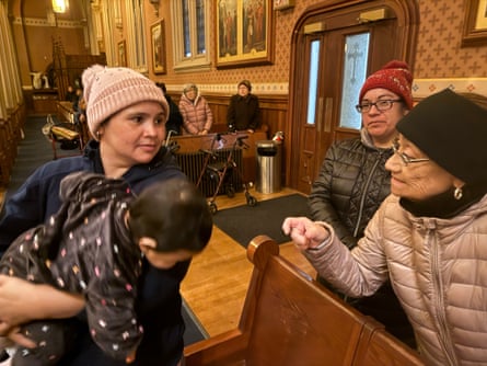 a woman holds her baby while looking at another woman