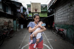 Trixia, 19, bottle feeds her four month-old daughter near her home in a deprived community in Navotas, Metro Manila, the Philippines.