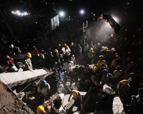 Rescue workers and residents search through the rubble in Cali