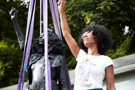 Jen Reid poses next to a sculpture by Marc Quinn portraying her, 14 July 2020. The statue was removed by the council within 24 hours