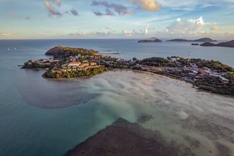 Aerial view at sunset of a bay with a peninsula covered in villas and islands in the distance