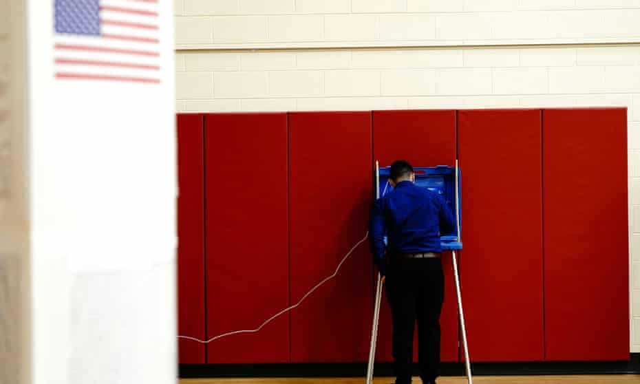 A voter completes his ballot inside a privacy booth at a polling station inside Knapp elementary school on election day in Racine, Wisconsin, 3 November.