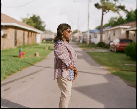 A middle-aged woman stands in a suburban street.
