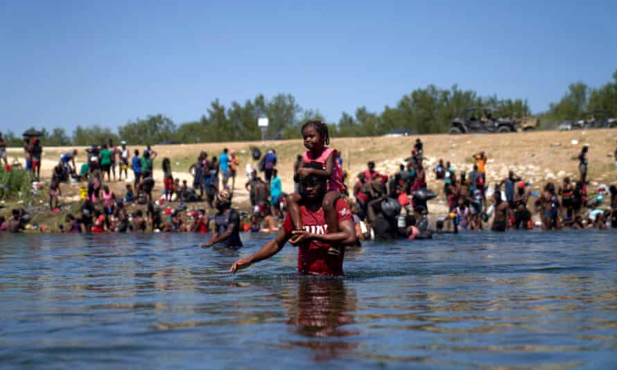 Thousands of migrants encamped in Del Rio, Texas, USAepa09478711 A man carrying a child on his shoulders wades across the Rio Grande river from the United States to Mexico, as thousands of migrants, many of them Haitian, remain camped under a bridge in Del Rio, Texas, USA, 20 September 2021. More than 14,000 people have crossed the Rio Grande river from Mexico creating a humanitarian crisis. The Biden administration has started to fly the migrants back to Haiti according to federal officials. EPA/ALLISON DINNER