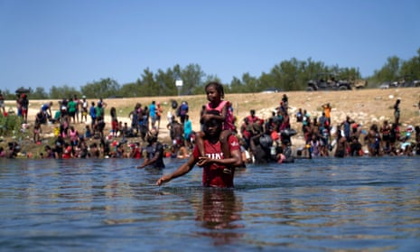 Thousands of migrants encamped in Del Rio, Texas, USA<br>epa09478711 A man carrying a child on his shoulders wades across the Rio Grande river from the United States to Mexico, as thousands of migrants, many of them Haitian, remain camped under a bridge in Del Rio, Texas, USA, 20 September 2021. More than 14,000 people have crossed the Rio Grande river from Mexico creating a humanitarian crisis. The Biden administration has started to fly the migrants back to Haiti according to federal officials. EPA/ALLISON DINNER