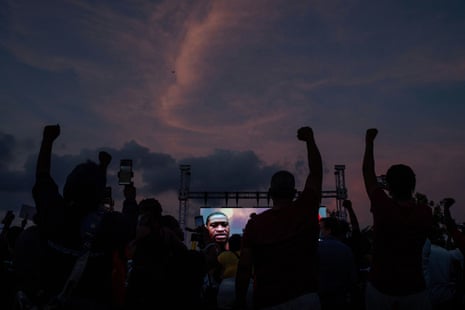 Residents raise hands in solidarity for George Floyd during vigil on his high school football field in Houston.