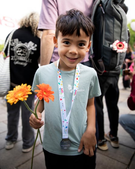 A little boy with some flowers and a medal round his neck