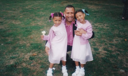 Shannon and Cheriece Hylton as infants, dressed identically in pink dresses, with their father Dwight.