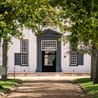 Diners sit under umbrellas outside the Jonkershuis restaurant's thatched-roof building at Groot Constantia