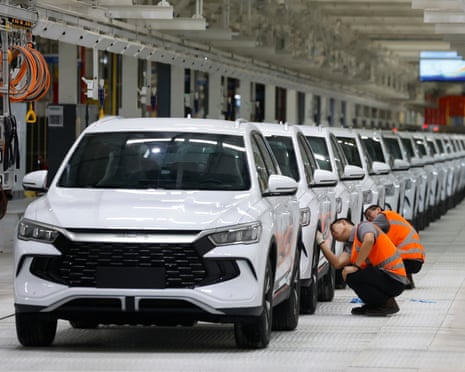 Workers clean vehicles during the inauguration of BYD’s factory in Camacari, Brazil