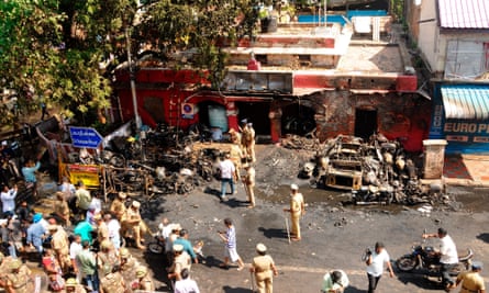 Crowds gather at the scene where vehicles were set ablaze in front of a police station in Chennai