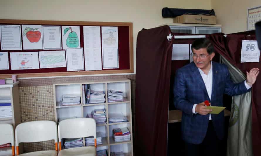 Turkish Prime Minister Ahmet Davutoglu holds his ballot as he leaves the polling booth during the parliamentary election in Konya, Turkey.
