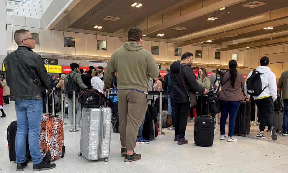 Passengers queue for check-in at Manchester airport's Terminal 2 on 4 April 2022
