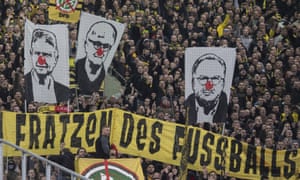 Fans hold up pictures of Dietmar Hopp, Fritz Keller and Karl-Heinz Rummenigge with red clown’s noses, venting their anger with the German soccer federation.