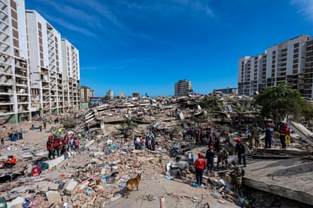 The aftermath of the quake with searchers going over mounds of rubble