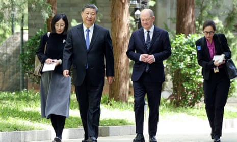 China's Xi Jinping and German's Olaf Scholz walk together in Beijing during talks on Tuesday