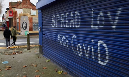 Residents passing graffiti reading “Spread Lov [sic] Not Covid” in Gipsyville, the ward with the highest Covid-19 infection rate in Hull.