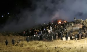 Protesters rallying against the Dakota Access Pipeline clash with police on a bridge over the Missouri River