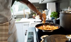 Close up of man cooking in kitchen<br>Close up of man in his 20s making dinner, squeezing lemon on pasta dish, hands only, healthy eating, healthy lifestyle, cooking