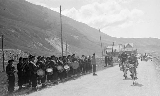 Gino Bartali and Fausto Coppi pass a marching band in the 17th stage (between Aosta, Italy and Briancon, France) of the 1949 Tour de France.