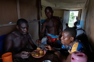 Komiyo Ikuejamoye, Bayo and Kayode Ikuejamoye gather after a day’s work to share a meal of rice and beetle pupae they collected from the forest