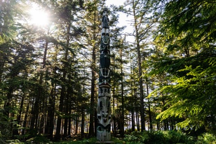 A totem pole among trees, with morning light.