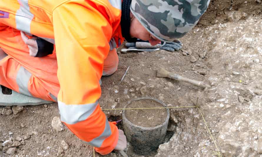An archaeologist excavates a bronze age vessel found during preliminary work on the A303 tunnel under Stonehenge.