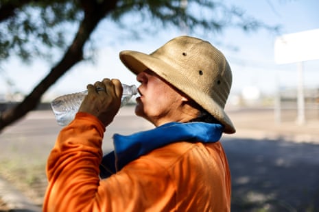 Person wearing hat drinks water