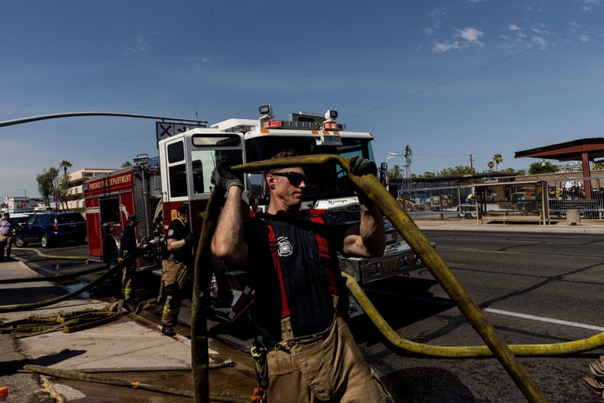 A firefighter holds up a yellow hose