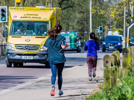 Joggers pass an ambulance on the south circular in London.