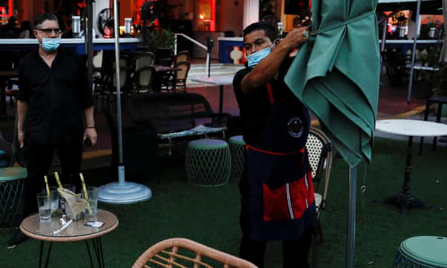 A man closes a restaurant ahead of an 8pm curfew.