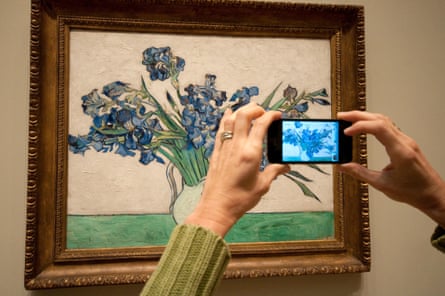 A woman snaps a photo of Iris by Vincent Van Gogh at the Metropolitan Museum of Art in New York.
