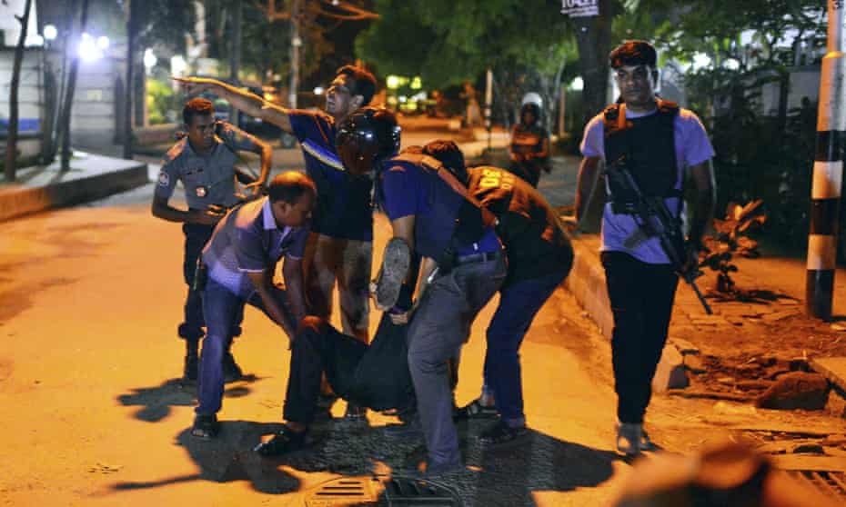 People help an unidentified injured person after a group of gunmen attacked a restaurant popular with foreigners in a diplomatic zone of the Bangladeshi capital Dhaka.