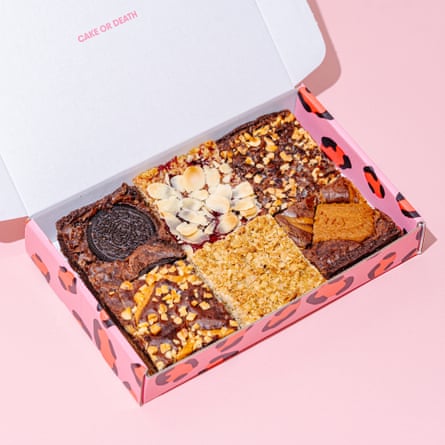 An open Cake or Death Ultimate Bakery Selection box on a pink background